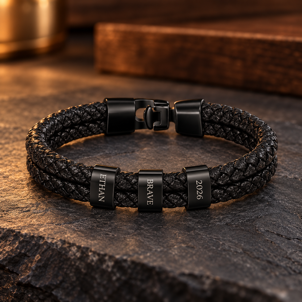 Personalized black braided leather bracelet with three engraved black rings reading Ethan, Brave, and 2026.