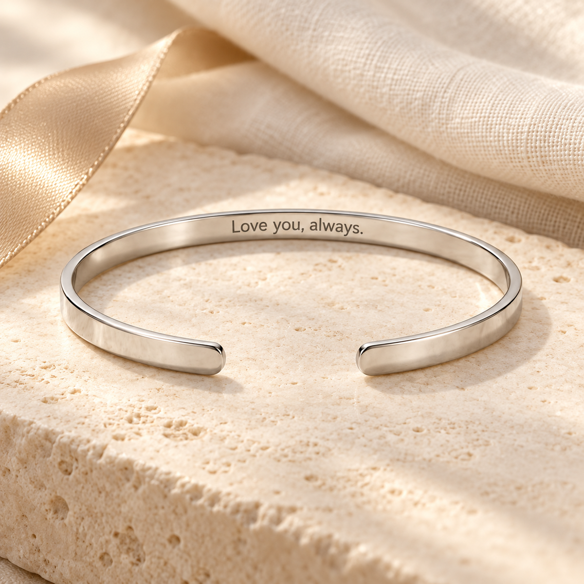 Close-up of silver cuff bracelet engraved with Love you always