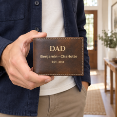 Man holding a personalized rustic Dad wallet with engraved names